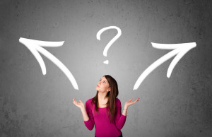 Pretty young woman making a decision with arrows and question ma